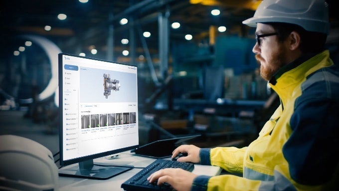 A person in a hard hat using a computer AI-generated content may be incorrect.